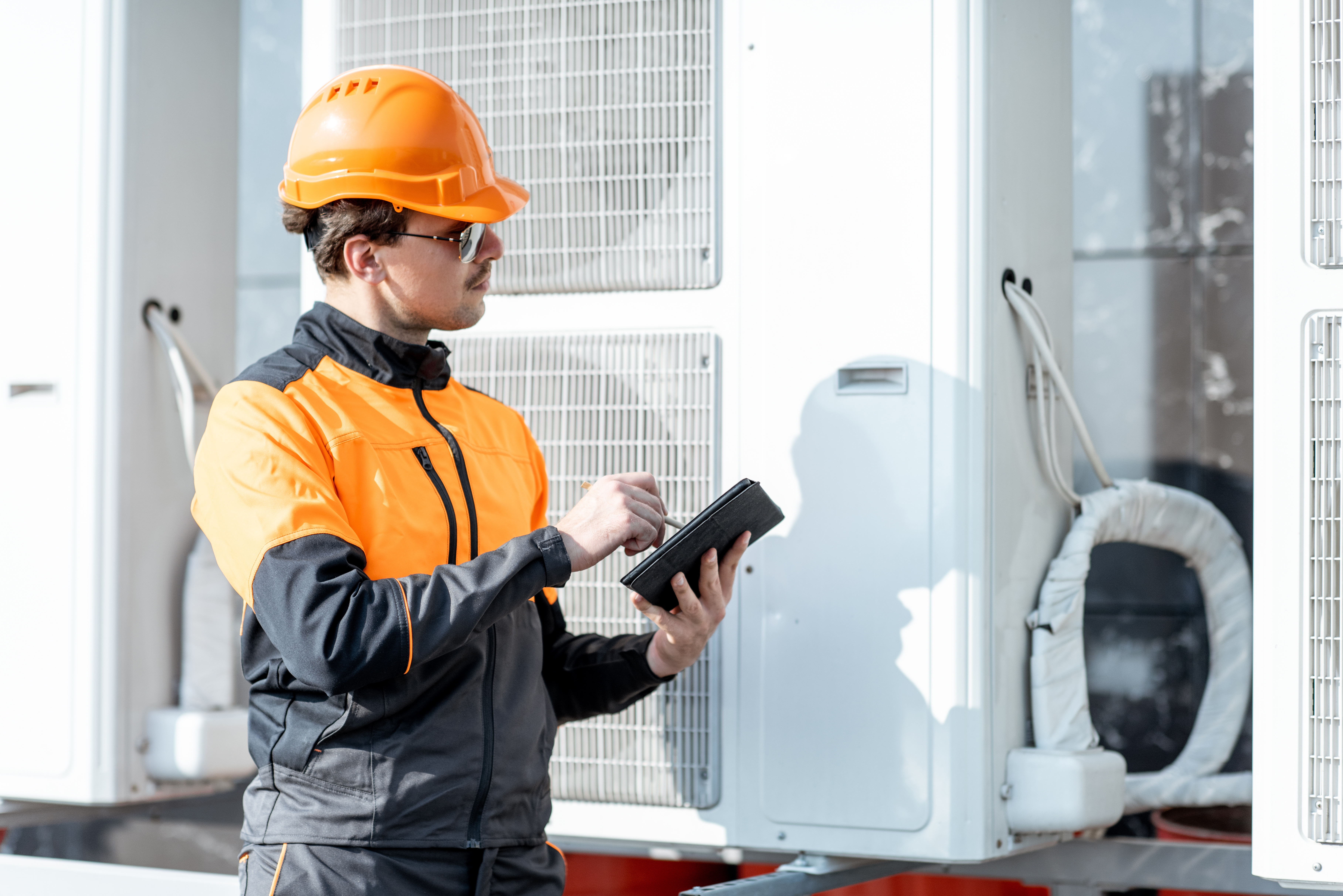 Workers are checking the heat pump. İşçiler ısı pompasını kontrol ediyor.