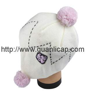 Cute knitted girl's winter hat with pom-pom
